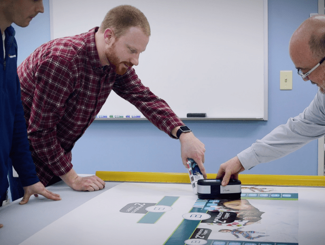 The team at Hummingbird reviewing a printed sample.